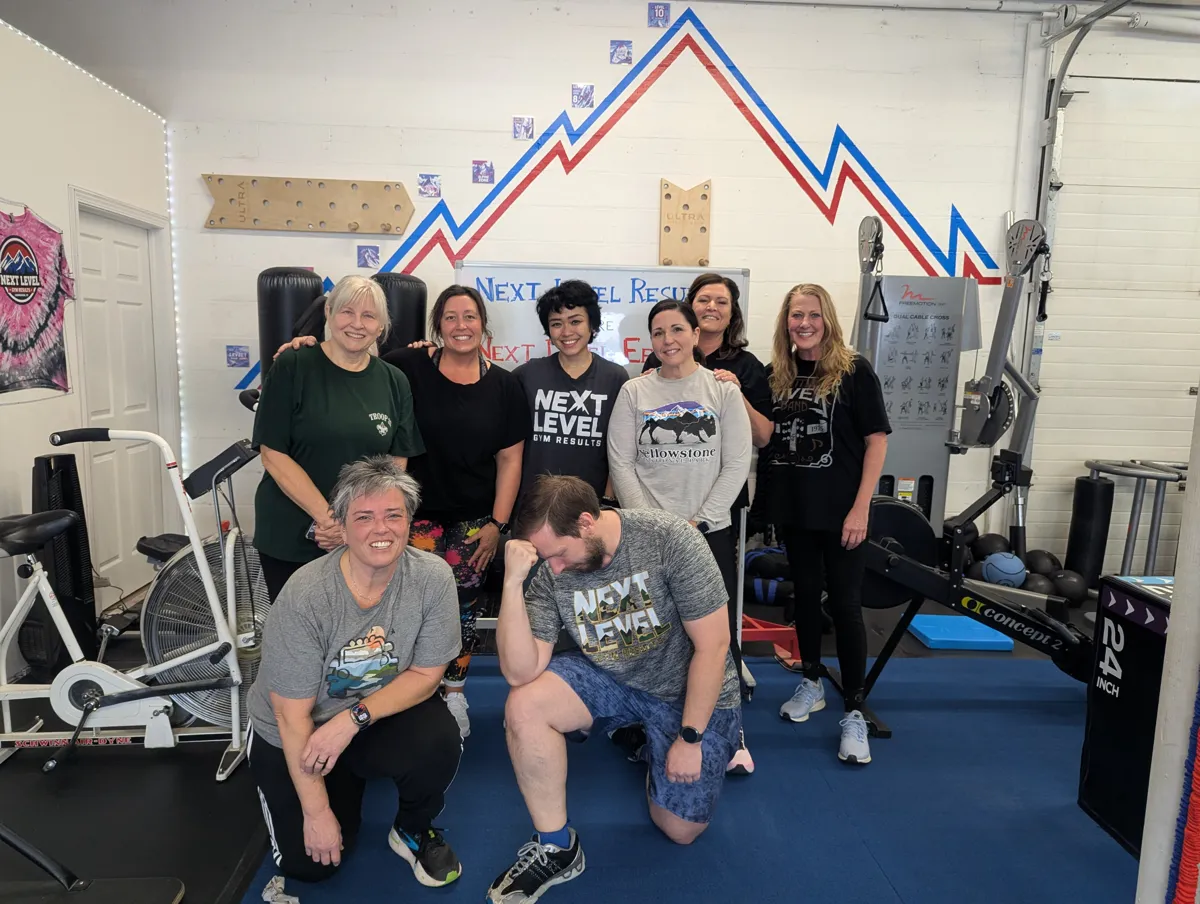 Next Level members together under the gym's mountain wall